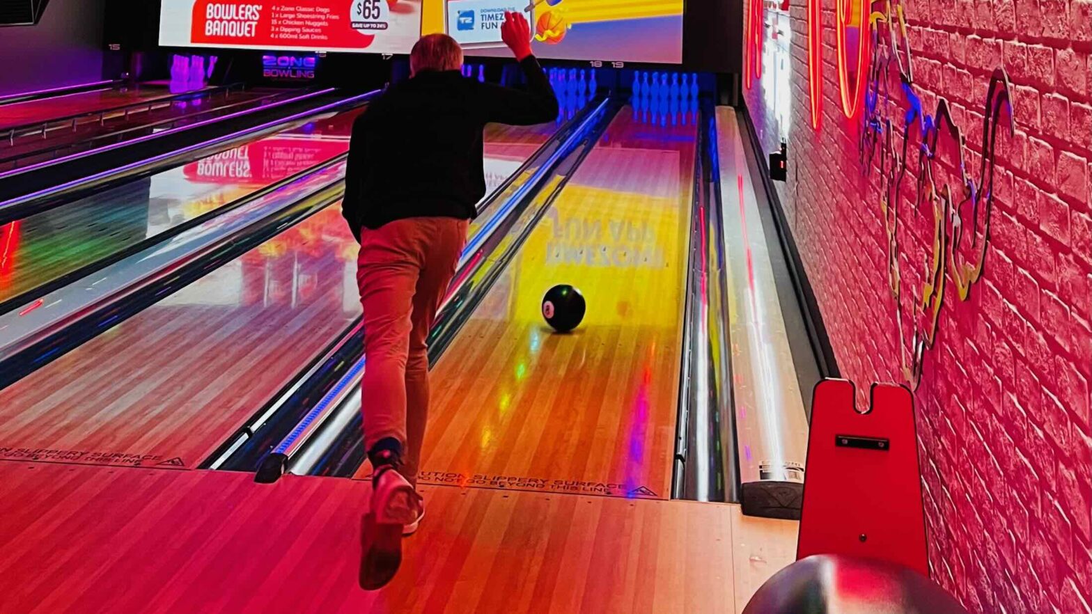 Jeremy bowling with one foot in the air.